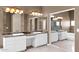 Elegant bathroom featuring double sinks, marble countertops, and decorative lighting fixtures at 16215 W Indianola Ave, Goodyear, AZ 85395