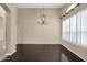 Bright dining room features dark hardwood floors, modern chandelier, and shuttered windows at 16215 W Indianola Ave, Goodyear, AZ 85395