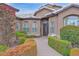 Close up of a home's entrance with arched windows, well-kept landscaping and a pathway to the front door at 16215 W Indianola Ave, Goodyear, AZ 85395