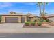 Charming home featuring a two-car garage, neutral color scheme, and well-maintained landscaping with palm trees and plants at 16215 W Indianola Ave, Goodyear, AZ 85395