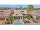 An inviting exterior features a well-maintained lawn, desert landscaping, and an attached three-car garage at 16215 W Indianola Ave, Goodyear, AZ 85395
