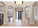 Open foyer featuring tile flooring, arched entryways, and a decorative light fixture with views to the living areas at 16215 W Indianola Ave, Goodyear, AZ 85395
