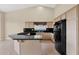 Bright kitchen featuring a black countertop island, cabinetry, and modern appliances, providing a functional space at 16215 W Indianola Ave, Goodyear, AZ 85395