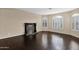 Living room boasts hardwood floors, large shuttered windows, and stone fireplace at 16215 W Indianola Ave, Goodyear, AZ 85395