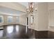 Spacious living room with hardwood floors, arched entries, plantation shutters and neutral paint color at 16215 W Indianola Ave, Goodyear, AZ 85395