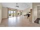 Open concept living area with tiled flooring, a ceiling fan, and backyard access at 16215 W Indianola Ave, Goodyear, AZ 85395