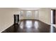 Living room with dark hardwood floors, plantation shutters, a corner fireplace and neutral color paint at 16215 W Indianola Ave, Goodyear, AZ 85395