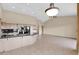 Open living space with a kitchen island, appliances, tile floors, and neutral walls at 16215 W Indianola Ave, Goodyear, AZ 85395