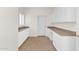 Practical mud room featuring white cabinets, counter space, and tiled flooring at 16215 W Indianola Ave, Goodyear, AZ 85395