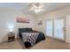 Cozy bedroom with a ceiling fan, double doors, and warm natural light at 1660 W 7Th Pl, Mesa, AZ 85201