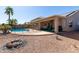 Relaxing backyard featuring a covered patio, pebble landscaping, a fenced pool, and an outdoor firepit at 17705 N Vera Cruz Ave, Maricopa, AZ 85139