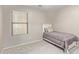 Neutral bedroom features a large window, soft carpet, and simple decor at 17705 N Vera Cruz Ave, Maricopa, AZ 85139