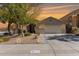 Charming single-story home showcasing well-maintained desert landscaping and a neutral color palette under a vibrant sunset sky at 17705 N Vera Cruz Ave, Maricopa, AZ 85139