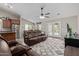 Spacious living room featuring vaulted ceilings, hardwood floors, patio access, and comfortable leather furniture at 17705 N Vera Cruz Ave, Maricopa, AZ 85139