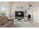 Bright living room with vaulted ceilings, wood-look floors, and a cozy seating area with a plush rug at 17705 N Vera Cruz Ave, Maricopa, AZ 85139