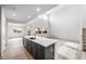 Bright, open kitchen with quartz island, recessed lighting, and wood-look tile floors at 17863 W Getty Dr, Goodyear, AZ 85338