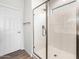 Shower featuring glass doors, tile surround and rainfall shower head at 17863 W Getty Dr, Goodyear, AZ 85338