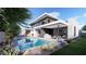 Spacious backyard featuring a pool, an outdoor kitchen, contemporary furniture and lush desert landscaping at 1830 E Palmaire Ave, Phoenix, AZ 85020
