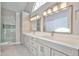Elegant bathroom featuring double sink vanity, stylish lighting, and glass-enclosed shower at 19824 N 94Th Ln, Peoria, AZ 85382
