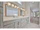 Bathroom with double sink vanity, modern lighting, and neutral tile floors at 19824 N 94Th Ln, Peoria, AZ 85382