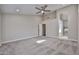 Carpeted primary bedroom with neutral walls, ceiling fan, and ensuite bathroom at 19824 N 94Th Ln, Peoria, AZ 85382