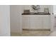 Bathroom vanity with white cabinets, a dark countertop and diamond tile flooring at 21276 W Berkeley Rd, Buckeye, AZ 85396