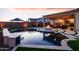 Backyard retreat with a shimmering pool, a cozy fire pit, and a relaxing outdoor seating area at 2535 E Thornton Ct, Gilbert, AZ 85297