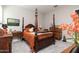 Elegantly appointed bedroom with a four-poster bed, dresser, and abundant natural light at 2535 E Thornton Ct, Gilbert, AZ 85297