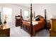Spacious bedroom with natural light featuring a four-poster bed, dresser, and carpeted floors at 2535 E Thornton Ct, Gilbert, AZ 85297