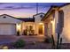 Inviting front exterior showcasing desert landscaping, paver driveway, and warm lighting at twilight at 2535 E Thornton Ct, Gilbert, AZ 85297