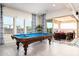 Well-lit game room features a pool table and sliding glass doors with access to the backyard at 2535 E Thornton Ct, Gilbert, AZ 85297
