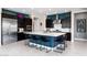 A modern kitchen features a large island with seating, dark cabinetry, stainless steel appliances, and sleek countertops at 2535 E Thornton Ct, Gilbert, AZ 85297