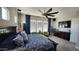 Spacious main bedroom with bright windows, ceiling fan, and furniture at 2535 E Thornton Ct, Gilbert, AZ 85297