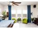 A well-lit bedroom with a large bed, ceiling fan, and window views showcasing modern and stylish decor at 2535 E Thornton Ct, Gilbert, AZ 85297