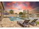 Backyard pool with a view of the serene lake, lounge chairs, and an umbrella for a perfect outdoor retreat at 3121 N Meadow Dr, Avondale, AZ 85392