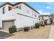 The white townhome exterior boasts a garage, an orange door, and desert landscaping at 3150 E Beardsley Rd # 1038, Phoenix, AZ 85050