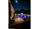 Night view of a backyard with a glowing pool and a fire pit with seating, creating an inviting outdoor space at 361 E Pinto Ct, Gilbert, AZ 85296