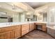 Large primary bathroom with double sinks, vanity area, large mirrors, and a soaking tub at 38408 N 23Rd Dr, Phoenix, AZ 85086