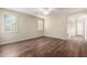 Empty bedroom featuring wood-look flooring, neutral paint, a ceiling fan, and an arched doorway at 38408 N 23Rd Dr, Phoenix, AZ 85086