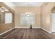 Bright dining room featuring wood floors, plantation shutters, and modern light fixture at 38408 N 23Rd Dr, Phoenix, AZ 85086