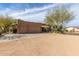 Exterior view of the property featuring a three-car garage, desert landscaping, and a well-manicured lawn at 38408 N 23Rd Dr, Phoenix, AZ 85086