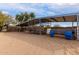 Metal framed, covered horse stalls featuring sand floor, metal gating, and blue water/feed troughs at 38408 N 23Rd Dr, Phoenix, AZ 85086