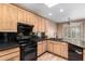 Kitchen features wood cabinets, black appliances, and granite countertops at 38408 N 23Rd Dr, Phoenix, AZ 85086