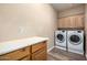 Laundry room with washer, dryer, cabinets, wood floors and countertop at 38408 N 23Rd Dr, Phoenix, AZ 85086