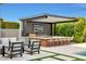 Outdoor kitchen with a covered patio, barbecue, seating and lush greenery, perfect for entertaining guests at 3915 N Holt Dr, Buckeye, AZ 85396