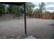 A backyard features a gravel ground cover surrounded by mature trees and a wood fence providing a private outdoor space at 4110 W Cholla St, Phoenix, AZ 85029