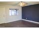 Open living room features hardwood floors, a ceiling fan, and natural light from the window at 4110 W Cholla St, Phoenix, AZ 85029
