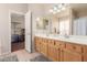 Well-lit bathroom with double vanity sinks, framed mirrors, and a door leading to the main bedroom at 4252 E Desert Sky Ct, Cave Creek, AZ 85331