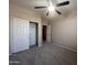 A carpeted bedroom with double door closet and modern ceiling fan with light fixture at 4252 E Desert Sky Ct, Cave Creek, AZ 85331