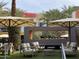 Stylish outdoor lounge with modern furniture, shade umbrellas, and a unique, linear fire pit at 602 N May St # 29, Mesa, AZ 85201